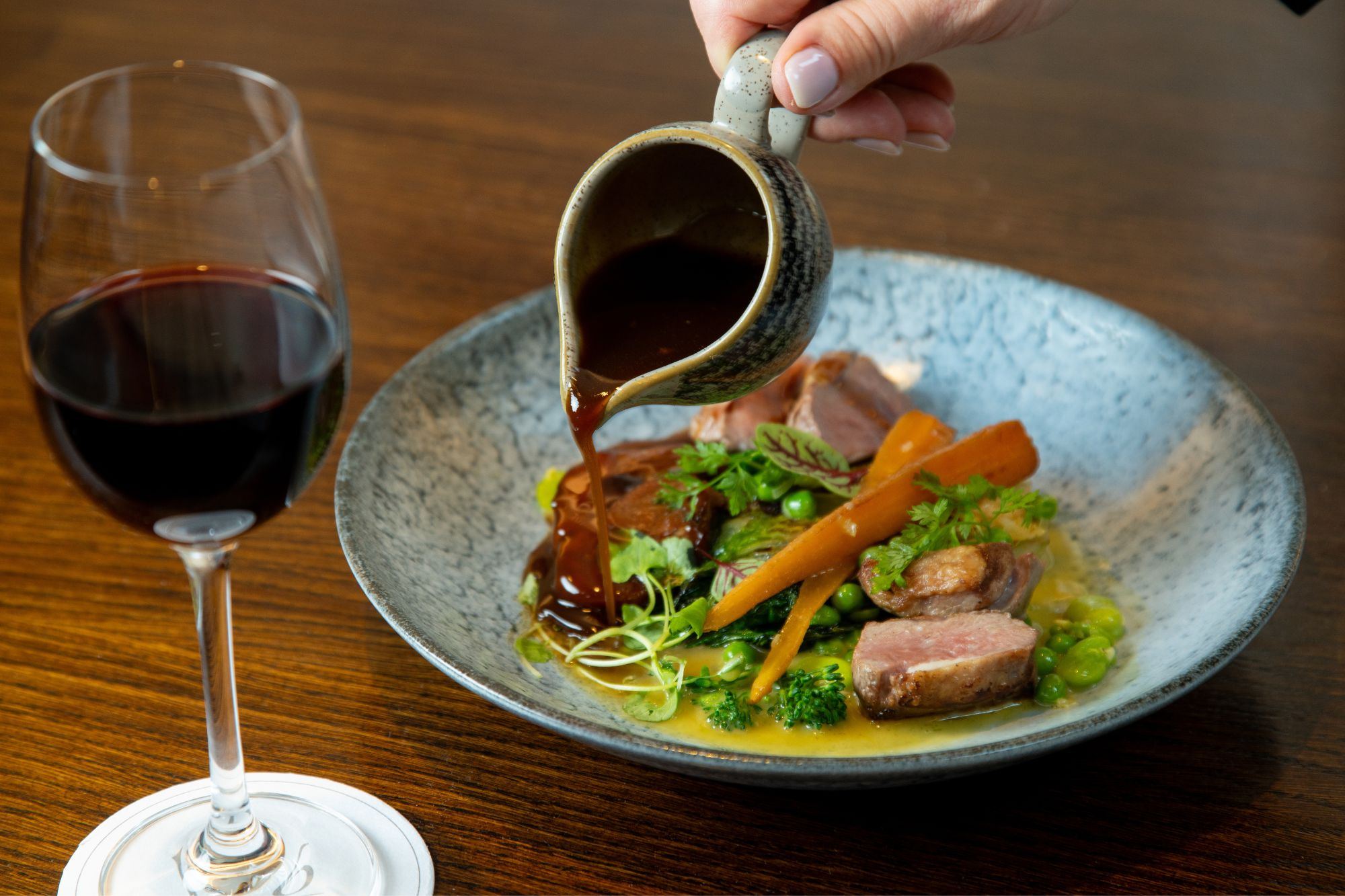 A lamb dish finished with gravy at the pass