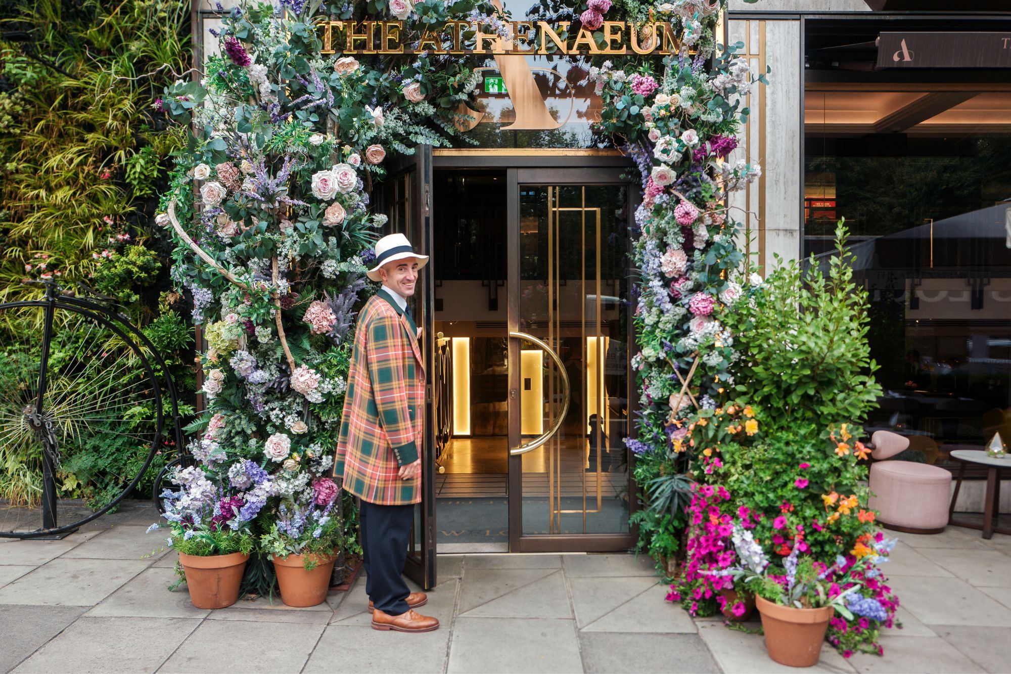 A doorman at the entrance of The Athenaeum on a summer afternoon in Mayfair